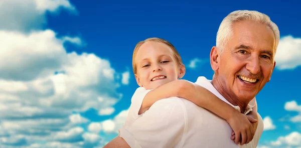 Дедушка держит внука на спине — стоковое фото