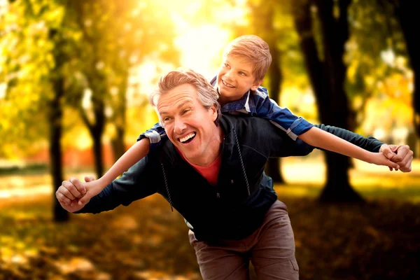 Padre dando hijo paseo a cuestas — Foto de Stock