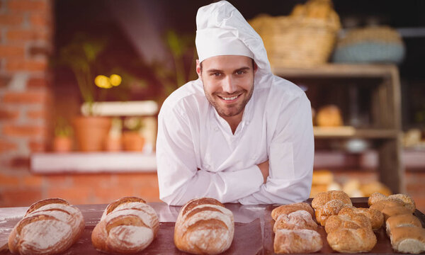 chef standing by bread at table