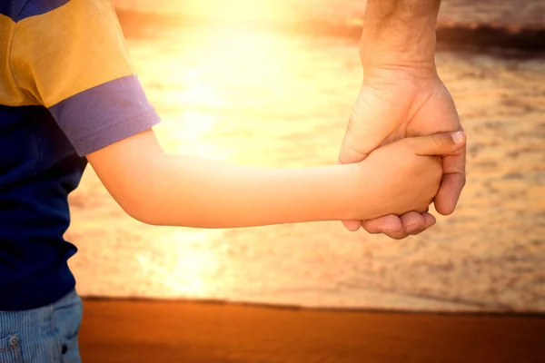 Padre sosteniendo hijo a mano — Foto de Stock