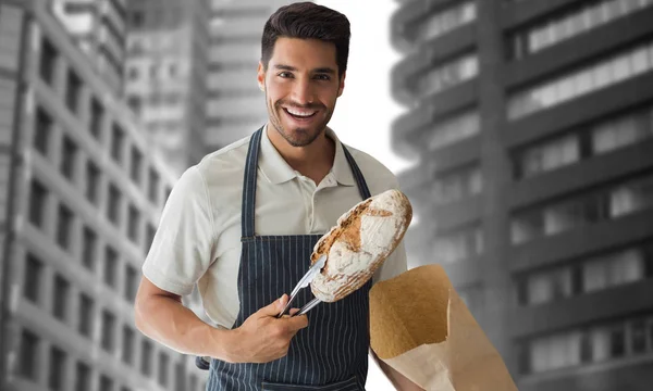 Bäcker packt Laib Brot ein — Stockfoto