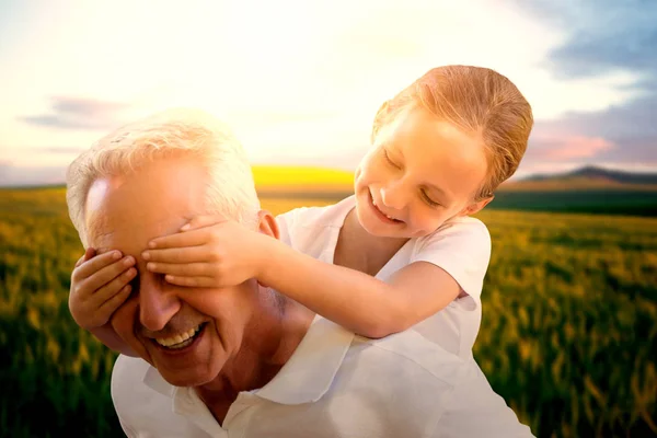 Petit-enfant couvrant les yeux du grand-père — Photo