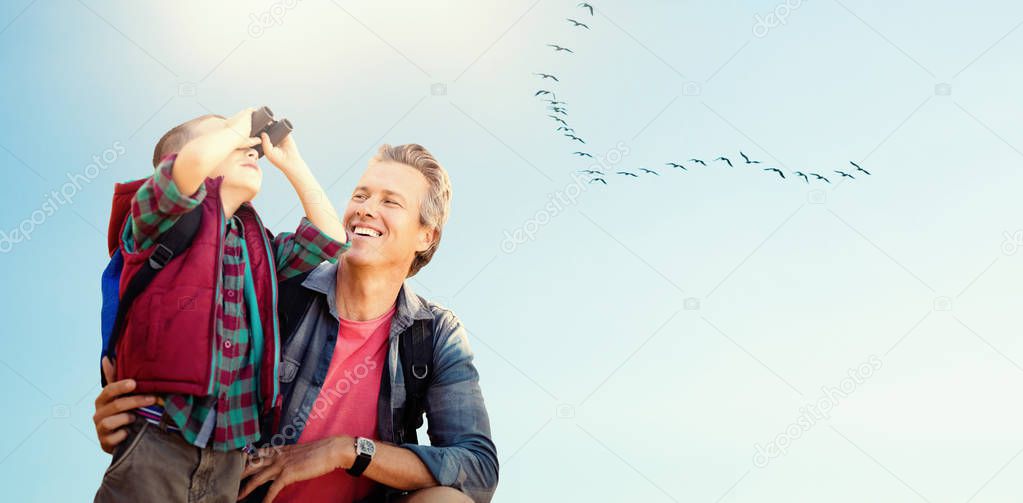 boy using binocular with father 