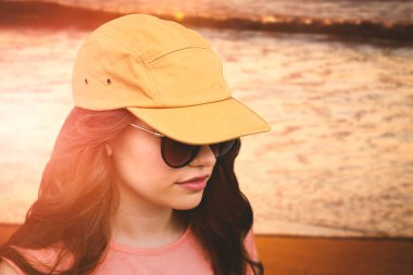 güneş gözlüğü ve şapka giyen kadın modeli