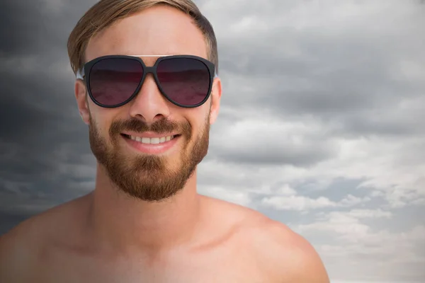 Muž na sobě sluneční brýle proti zatažené obloze — Stock fotografie