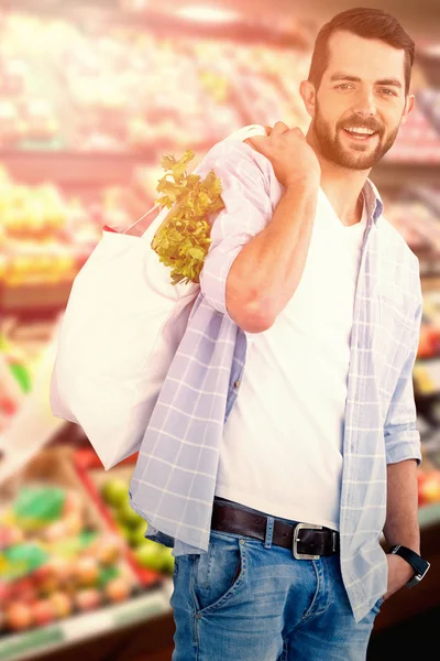 Homem carregando legumes no saco de compras — Fotografia de Stock