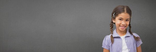 девушка, стоящая на фоне широкой серой
