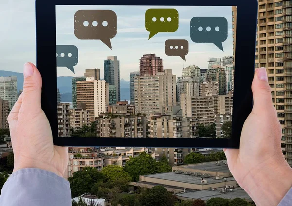 Tableta con iconos de burbujas de chat sobre la ciudad — Foto de Stock