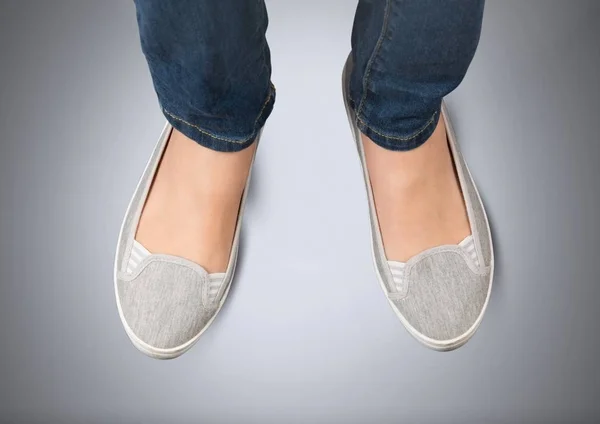 Weibliche Füße auf grauem Hintergrund — Stockfoto