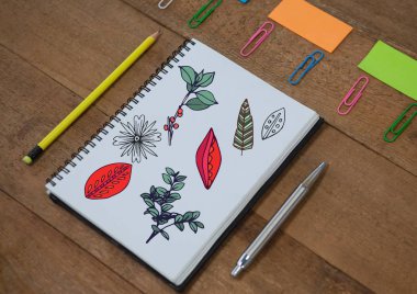 Ağaç dalları ve not defteri çizilmiş yapraklar