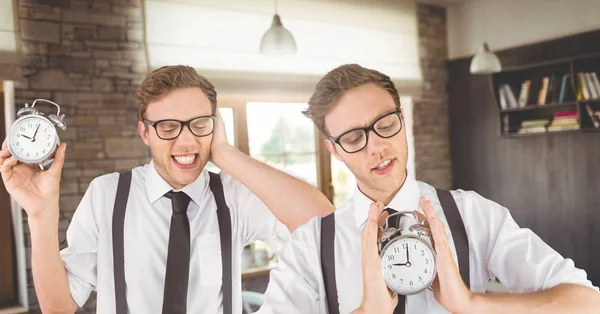 Близнюки в окулярах тримають годинники — стокове фото