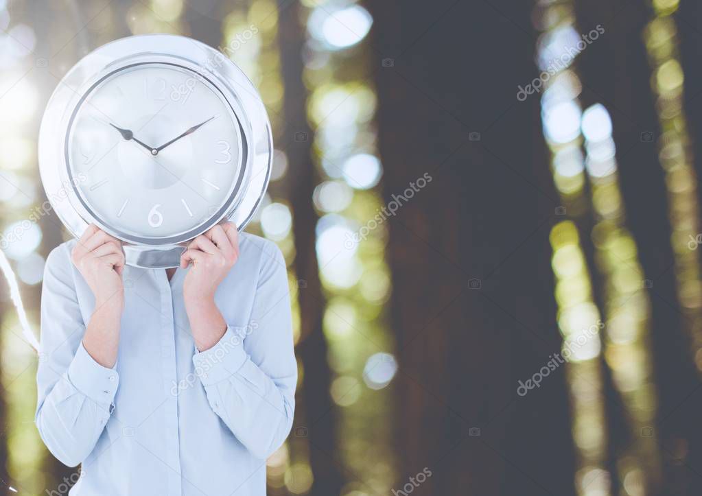 Woman holding clock hiding face