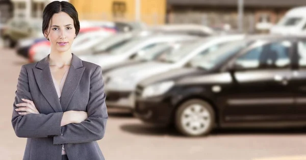 Mujer de negocios de pie contra el coche desenfocado —  Fotos de Stock