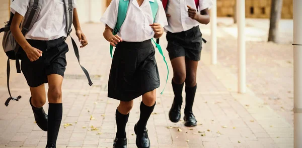 Miúdos da escola sorridentes a correr no corredor — Fotografia de Stock
