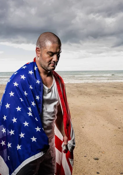 Hombre sosteniendo una bandera de EE.UU. en la playa — Foto de Stock