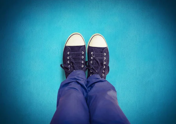 Black shoes on feet with blue background