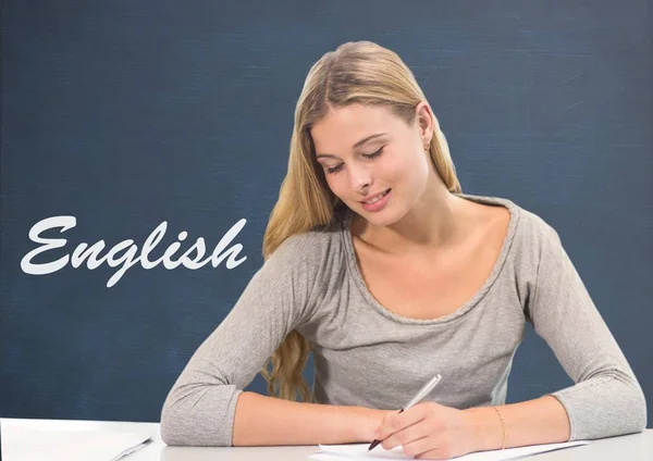 Student girl at table against blue blackboard with English text — Stock Photo, Image