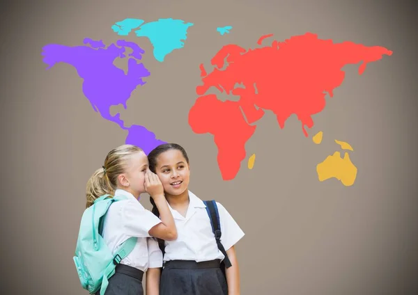 Meninas da escola sussurrando na frente do mapa do mundo — Fotografia de Stock