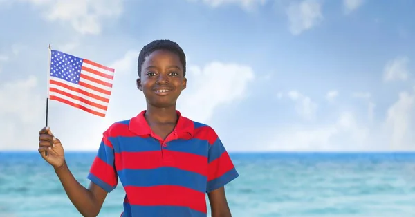 Gelukkige jongen houdt een vlag van de Verenigde Staten in het strand — Stockfoto