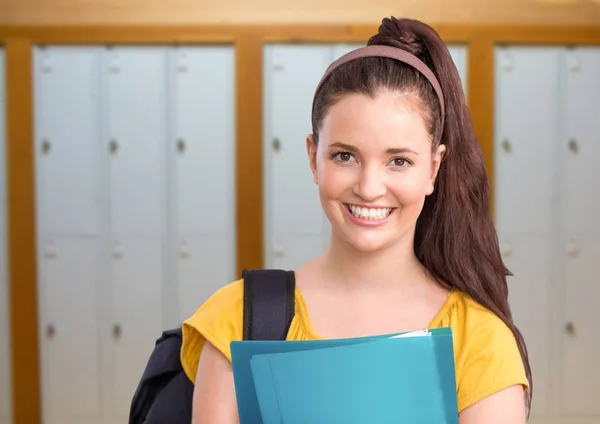 Estudiante femenina que sostiene la carpeta delante de los casilleros —  Fotos de Stock