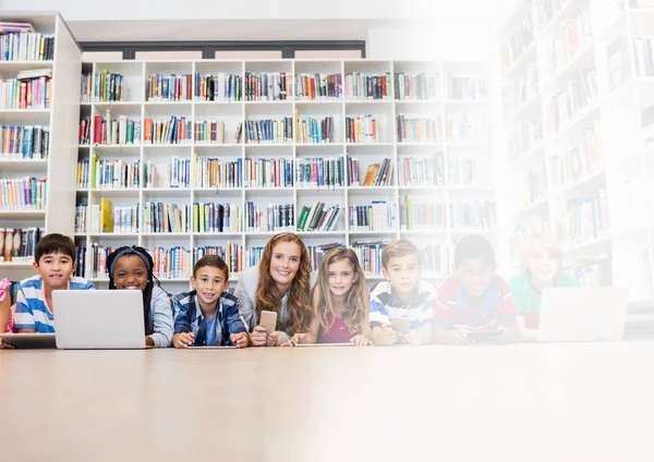 Grundschullehrerin mit Klasse in Bibliothek — Stockfoto