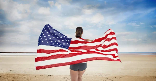 Vrouw met een vlag van de Verenigde Staten in het strand — Stockfoto