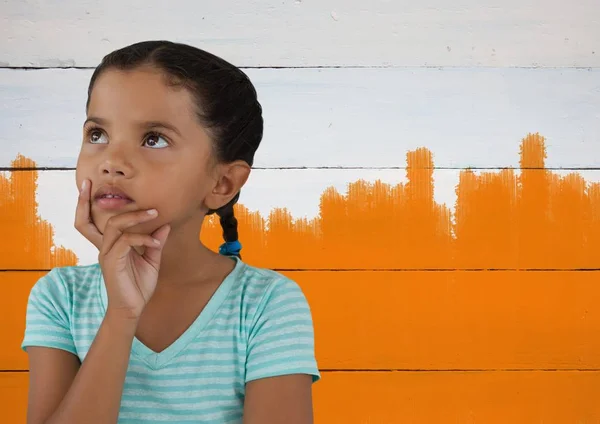 Το κορίτσι σκέφτεται μπροστά σε πορτοκαλί φόντο — Φωτογραφία Αρχείου
