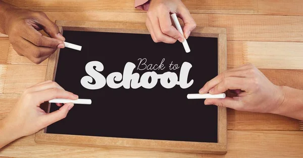 Handen schrijven terug naar school op blackboard — Stockfoto