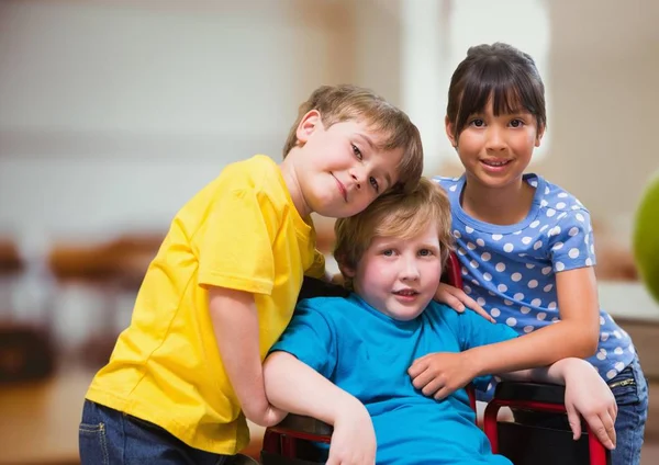 Menino com deficiência em cadeira de rodas com amigos — Fotografia de Stock