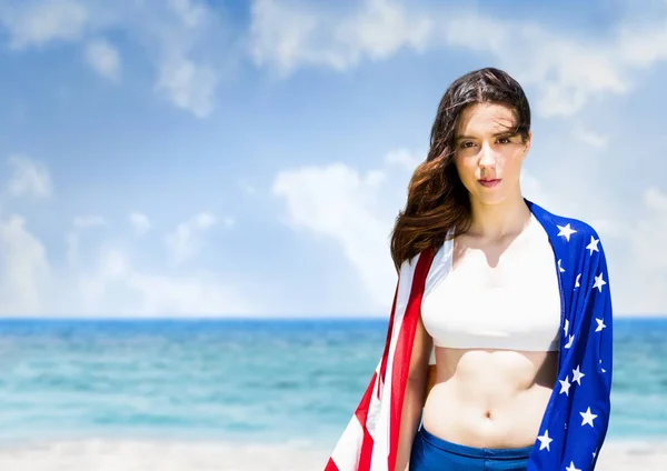 Mulher segurando uma bandeira dos EUA na praia — Fotografia de Stock