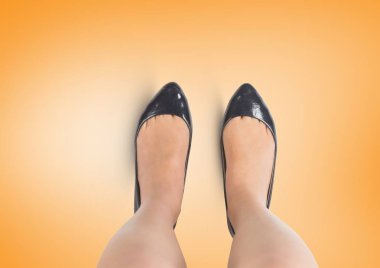 Ayakları ile sarı zemin üzerinde siyah ayakkabı