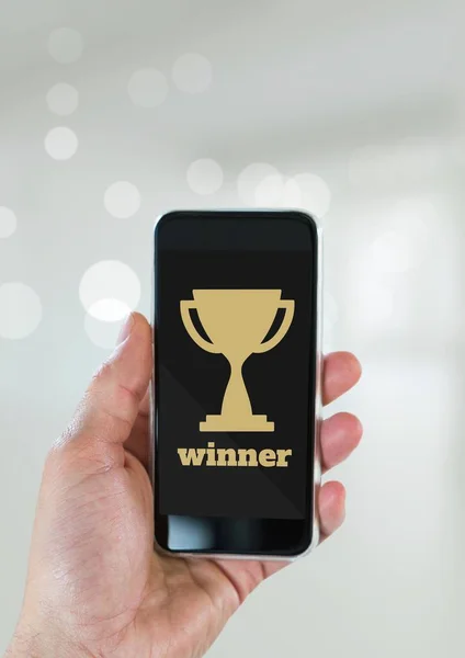 Person holding a phone with a trophy icon