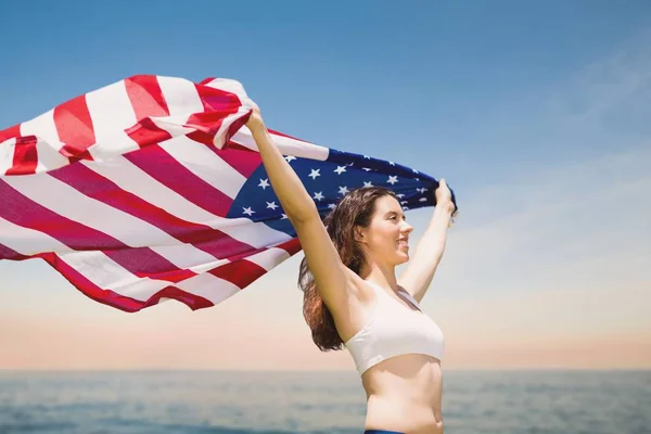 Vrouw met een vlag van de Verenigde Staten in het strand — Stockfoto