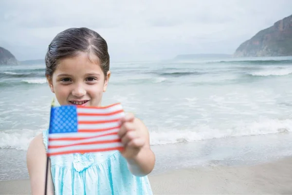 Chica sosteniendo una bandera de EE.UU. en la playa — Foto de Stock