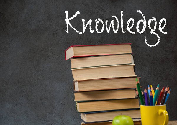 Knowledge text on blackboard with stack of books 