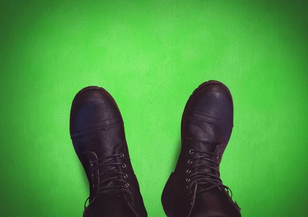 Czarne buty na nogach z zielonym tłem — Zdjęcie stockowe