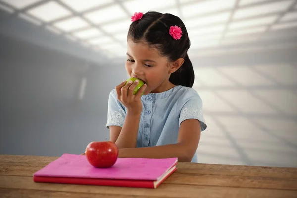 Niña comiendo manzana en la mesa — Foto de Stock