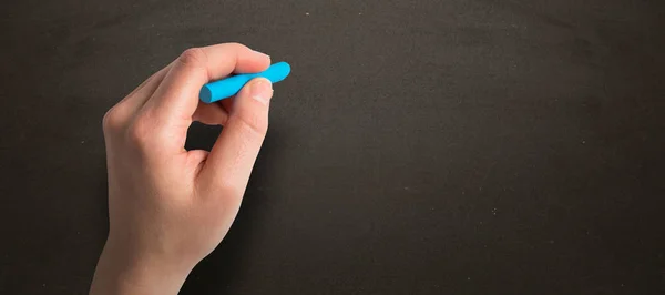 Hand holding blue chalk — Stock Photo, Image