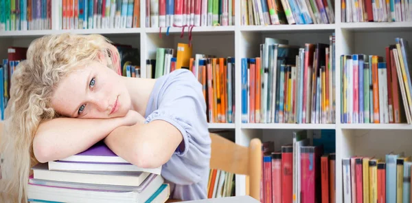 Unavený teenagera spaní v knihovně — Stock fotografie