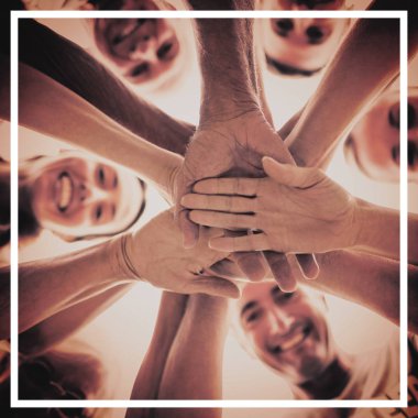 Mutlu gönüllüler birlikte ellerini koyarak 