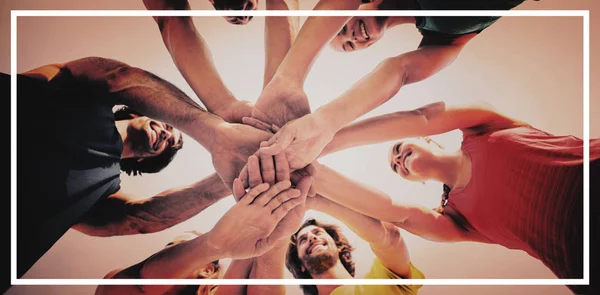 Amigos de pie con las manos apiladas contra el cielo — Foto de Stock