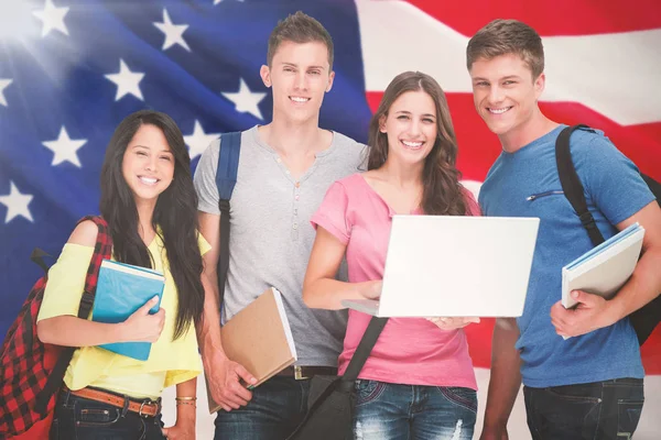 bir dizüstü bilgisayar tutan öğrenciler