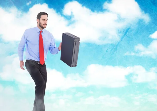 Podnikatel, drží aktovku v obloha mraky — Stock fotografie