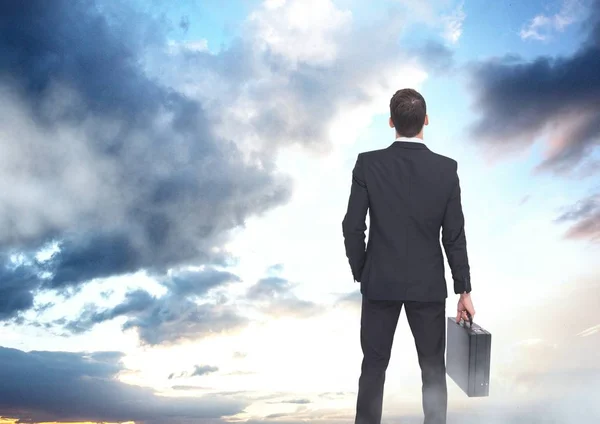 Hombre de negocios sosteniendo maletín en cielo abierto nube — Foto de Stock