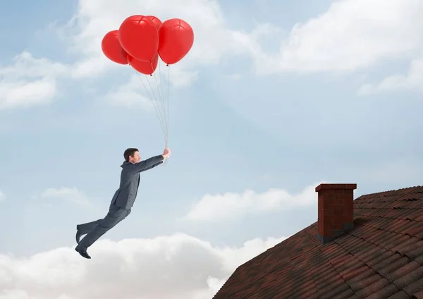 Geschäftsmann schwebt mit Luftballons auf Dach — Stockfoto