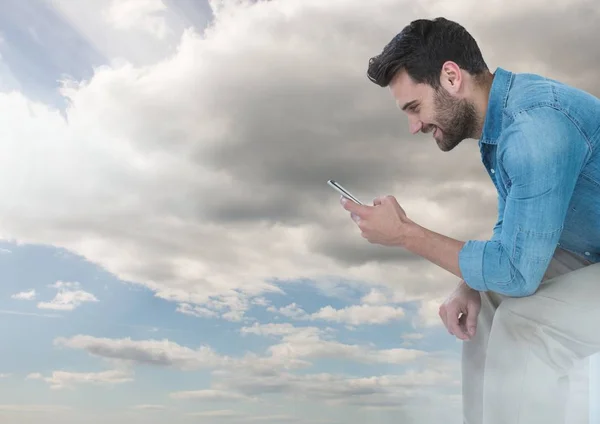Muž na telefonu pod obloha mraky — Stock fotografie
