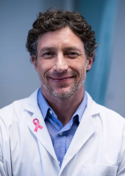 Doctor with breast cancer awareness ribbon — Stock Photo, Image