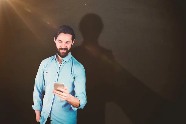 Composietbeeld van glimlachende man gebruik mobiele telefoon — Stockfoto