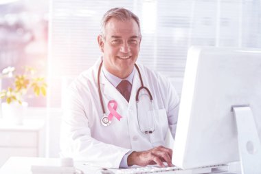 erkek doktor klinikte bilgisayar kullanarak