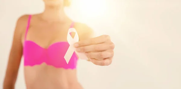 Woman in pink bra holding ribbon — Stock Photo, Image